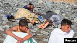 Migrants rest after landing in a dinghy at Aguila beach on the island of Gran Canaria, Spain November 29, 2019.