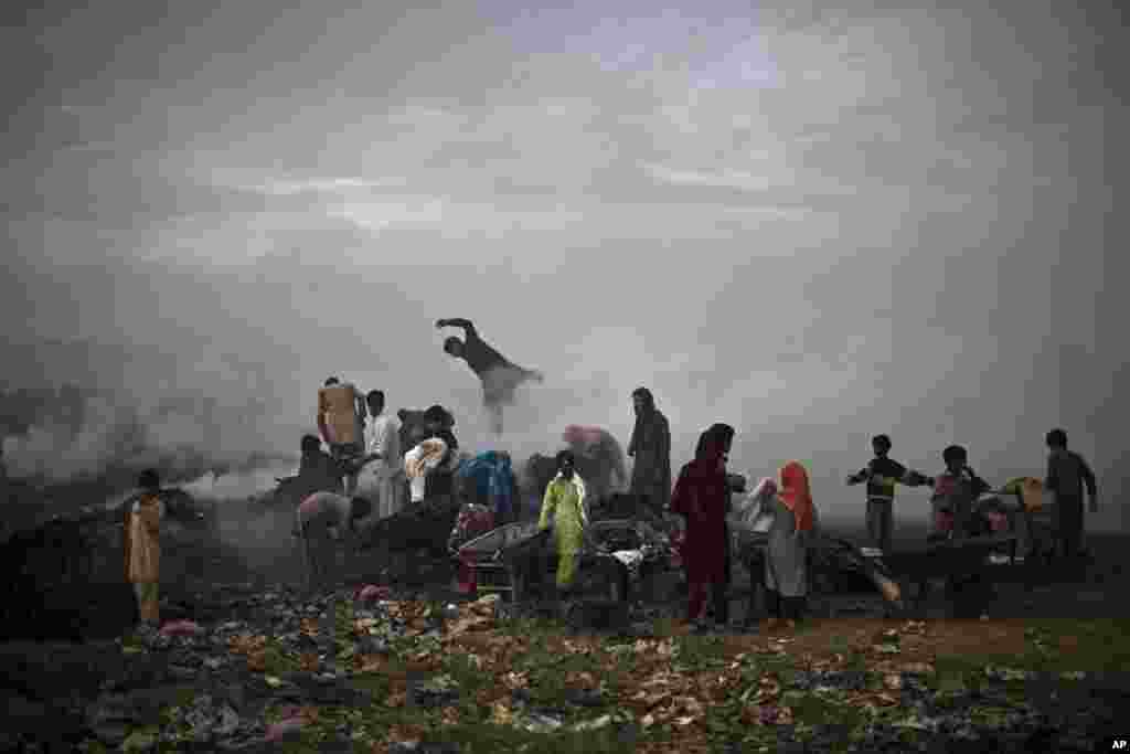 Pakistanis survey a burning field, which was used by fruit and vegetable sellers to store their wooden boxes, on the outskirts of Islamabad.