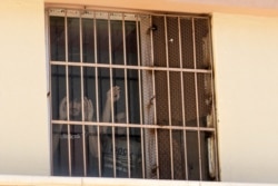 Afghan refugees detained in a Turkish deportation center watch journalists touring their facility with Turkish officials in Van, Turkey, Aug. 30, 2021. (VOA/Yan Boechat)