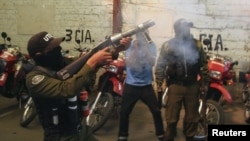 Un policía antimontines dispara gas lacrimógeno durante una protesta de la policía contra el gobierno de Evo Morales, en demanda de incrementos salariales.