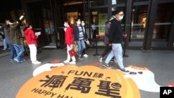 Para pejalan kaki mengenakan masker saat berjalan-jalan di distrik perbelanjaan di Taipei, Taiwan, Kamis, 29 Oktober 2020. (Foto AP / Chiang Ying-ying)
