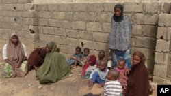 Anak-anak dan istri dari mereka yang diduga anggota sekte Boko Haram di Nigeria, menyusul penggerebekan di Kano. (Foto: Dok)