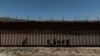 Una vista de un dron muestra a migrantes solicitantes de asilo mientras caminan a lo largo del muro fronterizo tras cruzar la frontera hacia los EEUU, en Jacumba Hot Springs, California, visto desde México, el 16 de mayo de 2024.