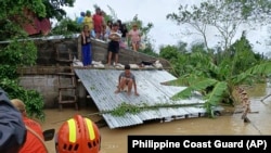 Warga berada di atas atap untuk menghindari banjir, sambil menunggu evakuasi dari tim penyelamat di Libon, provinsi Albay, Filipina, 23 Oktober 2024 (foto: dok). Filipina di urutan teratas negara yang paling berisiko terhadap krisis iklim. 