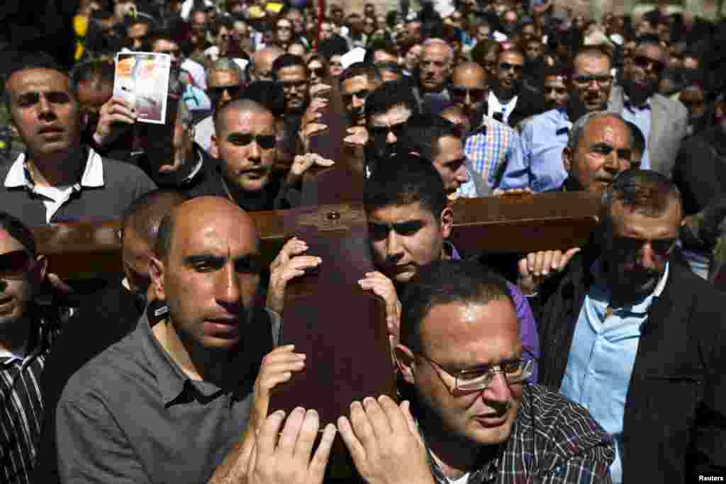 Christians carry a cross during a procession along the Via Dolorosa on Good Friday during Holy Week in Jerusalem's Old City, April 3, 2015.