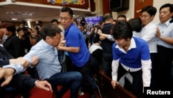 Anggota legislatif Partai Demokratik Progresif (DPP) Chao Tien-lin, pergi dan bentrok dengan legislator Kuomintang (KMT) oposisi selama pertemuan anggaran untuk program pembangunan infrastruktur, di Badan Legislatif Yuan di Taipei, Taiwan, 18 Juli 2017.