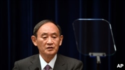Japan's Prime Minister Yoshihide Suga attends a news conference with chairman of the government's pandemic advisory panel Shigeru Omi, not pictured, at the prime minister's official residence in Tokyo, Wednesday, Aug. 25, 2021. Japan has expanded…