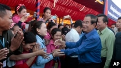 Prime Minister Hun Sen greets garment workers during a visit to a factory outside of Phnom Penh, Cambodia, Wednesday, Aug. 30, 2017. Hun Sen embarked on a country-wide trip to visit the nation's factory workers to hear their hopes and concerns in person.