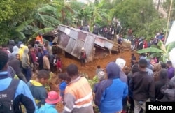 Locals surround a house that was covered by a landslide in the town of Mendi after an earthquake struck Papua New Guinea's Southern Highlands in this image taken Feb. 27, 2018, obtained from social media.