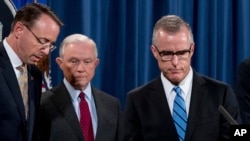 El Director Interino del FBI Andrew McCabe, a la derecha, acompañado por el Fiscal General Jeff Sessions, segundo desde la izquierda. El Vice Fiscal Rod Rosenstein, sube al podio en una conferencia de prensa en el Departamento de Justicia el 20 de julio de 2017 en Washington.
