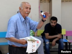 Un hombre gesticula mientras lleva una papeleta en una mesa electoral ubicada en una escuela durante las elecciones en Estambul, Turquía, el 24 de junio de 2018.