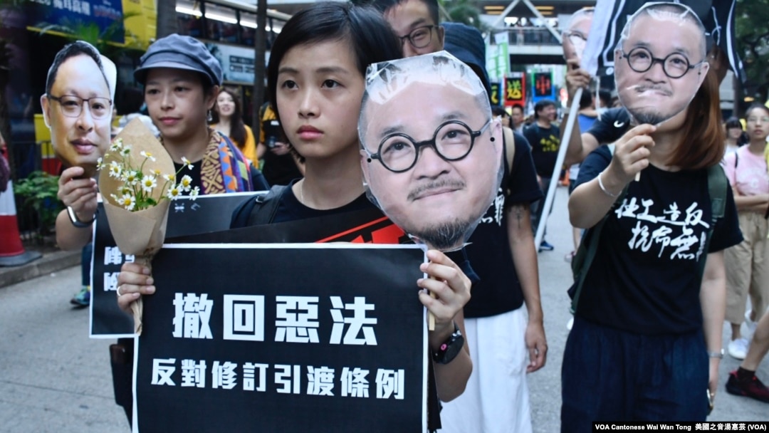 遊行人士手持在監獄服刑的邵家臻及戴耀廷的頭像,代替他們出來遊行 (攝影:美國之音湯惠芸)