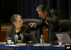 University of California President Janet Napolitano, left, talks with regent Hadi Makarechian at a Board of Regents meeting.