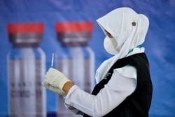 Seorang petugas kesehatan menyiapkan vaksin COVID-19 Sinovac dalam vaksinasi massal di Banda Aceh, 7 Juni 2021. (Foto: CHAIDEER MAHYUDDIN / AFP)