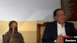 سلمان تاتیر ذرائع ابلاغ سے بات کر رہے ہیں اور عقب میں آسیہ بی بی بیٹھی ہیں۔(2010ء کی ایک تصویر)