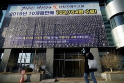 Seorang pria yang mengenakan masker untuk mencegah tertular virus corona tengah berjalan melewati Gereja Shincheonji Yesus di Daegu, Korea Selatan 21 Februari 2020. (Foto: Reuters/Kim Hong-Ji)
