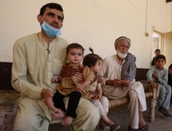 Tariq Nawaz menggendong bayinya, Tuba, yang menderita Polio di Suleiman Khel, Pakistan, 6 Mei 2021. (Foto: AP Photo/Muhammad Sajjad)