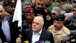 Le Premier ministre Haider al-Abadi (c.) à Ramadi (archives)