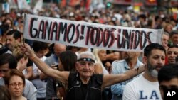 Un hombre con el mensaje "¡Ganamos! Todos unidos" se une a los partidarios del candidato presidencial peronista de centroizquierda Alberto Fernández y su actual candidata, la ex presidenta Cristina Fernández, afuera de la sede electoral de su partido 27