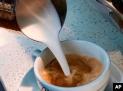 FILE - A barista pours steamed milk into a cup of coffee at a cafe in Los Angeles, Sept. 22, 2017. State health officials proposed a regulation change Friday that would declare coffee doesn't present a significant cancer risk, countering a California court ruling.