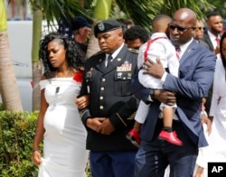 FILE -Myeshia Johnson, widow of U.S. Army Sergeant La David Johnson, who was among four special forces soldiers killed in Niger, is escorted into his graveside service in Hollywood, Florida, Oct. 21, 2017.