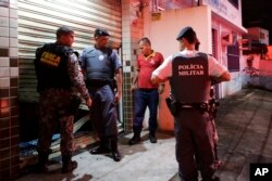 Military police check the broken entrance of a store that was looted in Vitoria, Espirito Santo state, Brazil, Feb 8, 2017.