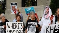 La gente sostienen carteles en la Embajada de Arabia Saudita durante una protesta por la desaparición del periodista saudí Jamal Khashoggi, el 10 de octubre de 2018, en Washington.