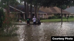 Three men prepare to kayak down their street to help out those in need, as well as find food and other supplies. (Photo courtesy of Abby TerHaar)