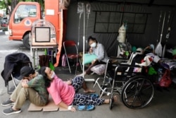 Seorang pasien COVID-19 beristirahat di luar tenda darurat yang didirikan di luar rumah sakit di tengah lonjakan kasus COVID-19 di Bekasi, 25 Juni 2021. (Foto: Willy Kurniawan/Reuters)