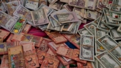 Dinero falso en miniatura está a la vente en la Feria anual de Alasita en La Paz, Bolivia, el lunes 24 de enero de 2022. (AP Foto/Juan Karita)