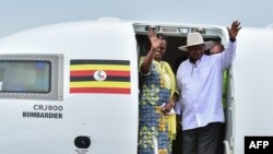 Le président ougandais, Yoweri Museveni (à droite) et la Première Dame, Janet Museveni (à droite), quittent un avion nouvellement acquis de la compagnie Uganda Airlines Bombardier CRJ900 sur la piste de l'aéroport d'Entebbe, à la périphérie de Kampala, le