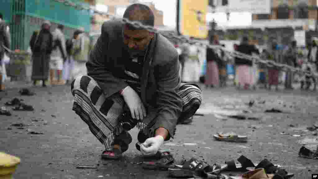 Un agent de sécurité yéménite inspecte le lieu de l’attentat suicide à Sanaa, Yémen, jeudi, le 9 ocotbre 2014. AP Photo.