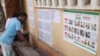 Les électeurs examinent une liste électorale devant un bureau de vote dans le quartier de Be à Lomé le 20 décembre 2018 lors de la procédure de vote pour les élections législatives.