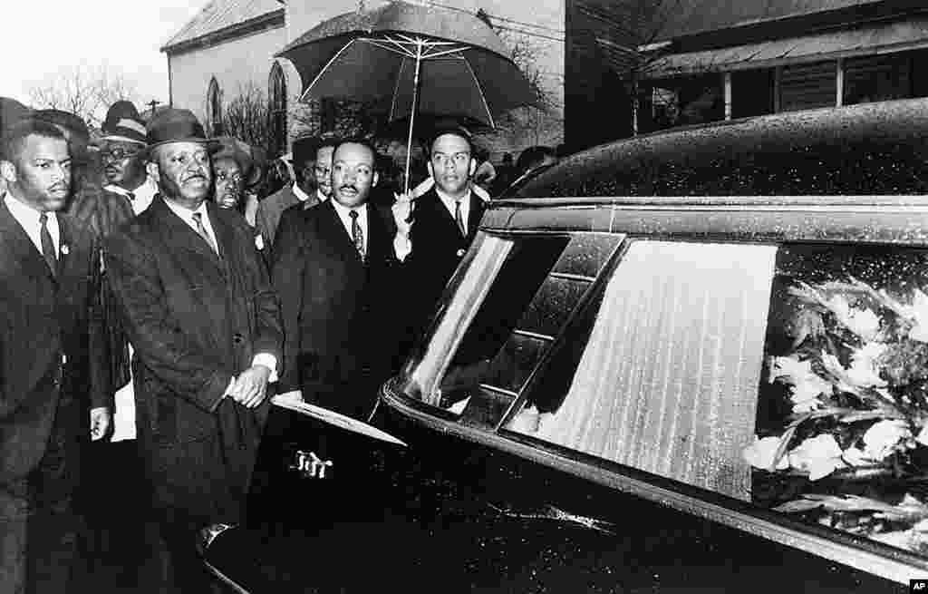Martin Luther King, Jr. dan rekan-rekannya memimpin iring-iringan di belakang peti jenazah Jimmy Lee Jackson saat upacara pemakaman di Marion, Alabama, 1 Maret 1965.