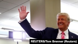 Le président américain Donald Trump salue les spectateurs après avoir voté lors de l'élection présidentielle de 2020 à la bibliothèque du comté de Palm Beach à West Palm Beach, Floride, États-Unis, le 24 octobre 2020.