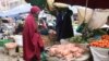 A woman buys vegetables from a local vendor in the Eastleigh neighborhood of Nairobi. The neighborhood is under lockdown after a spike in COVID-19 cases. (Mohammed Yusuf/VOA)