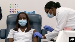 Sandra Lindsay (kiri), seorang perawat di Long Island Jewish Medical Center, sedang menerima vaksinasi vaksin Covid-19 dari Pfizer-BioNTech, di Queens, New York, 14 Desember 2020. 
