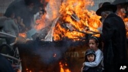 Ultra-Orthodox Jewish men and children burn leavened items in final preparation for the Passover holiday in the ultra-Orthodox Jewish town of Bnei Brak, near Tel Aviv, Israel, March 26, 2021.