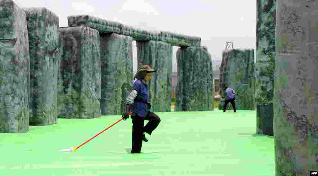Pekerja membersihkan sebuah patung karya seniman Inggris Jeremy Deller berjudul "penghujatan" sehari sebelum pameran yang terbuka untuk umum di Hong Kong.