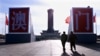 Turis berjalan menuju dua huruf raksasa China bertuliskan "Macau" yang dipasang di depan Monumen Pahlawan Rakyat di tengah Lapangan Tiananmen pada 16 Desember. (Foto: Reuters)