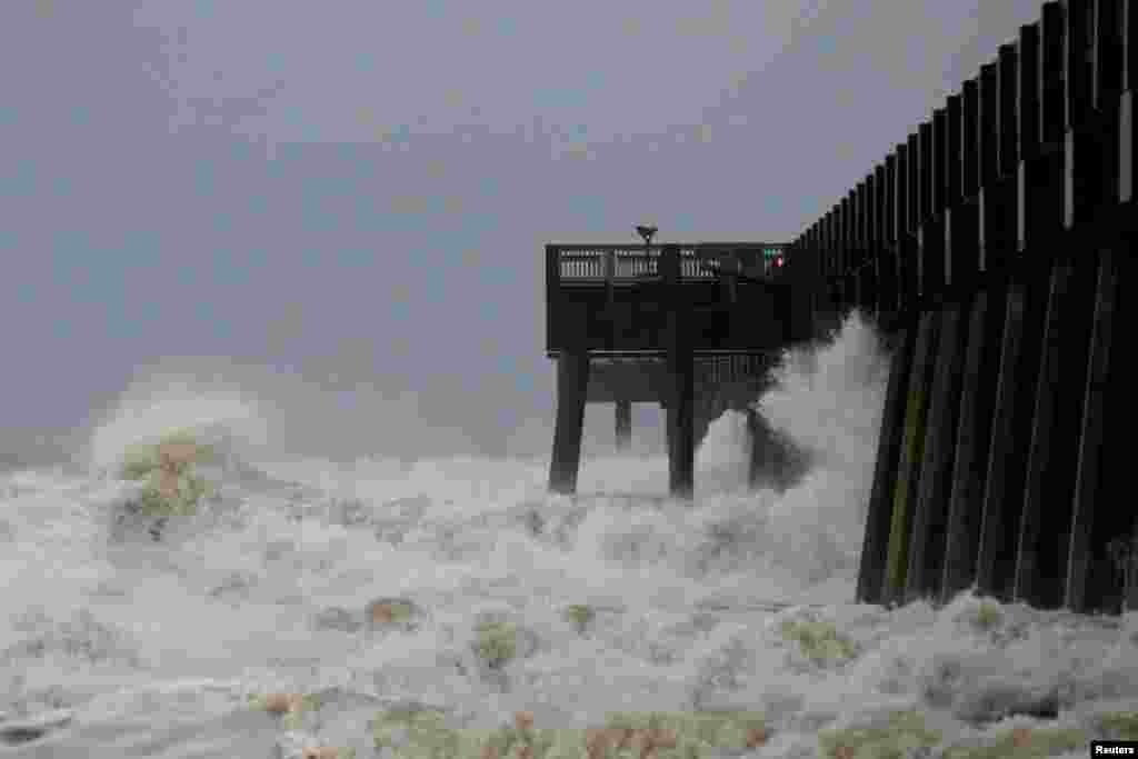 Waves crash along a pier as Hurricane Michael approaches Panama City Beach, Florida, Oct. 10, 2018.