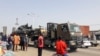 Des passants regardent un char transporté par camion dans les rues de N'Djamena, Tchad, le 3 janvier 2020