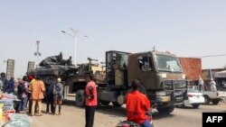 Warga mengamati sebuah tank yang diangkut dengan truk melalui jalan-jalan N'Djamena, Chad, 3 Januari 2020, saat pasukan Chad kembali dari misi memerangi Boko Haram di Nigeria. (Foto: dok).