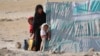 Une Afghane et ses filles dans un camp de déplacés internes en périphérie de Mazar-e-Sharif, le 8 juillet 2021.