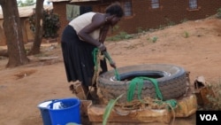A woman draws water from an unprotected well in Chigwirizano, a peri-urban area hit by a Cholera outbreak in Malawi. (Photo: Lameck Masina for VOA)