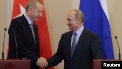 Predsjednici Turske i Sirije rukuju se na konferenciji za novinare poslije razgovora u Sočiju, u Rusiji, 22. oktobar 2019.