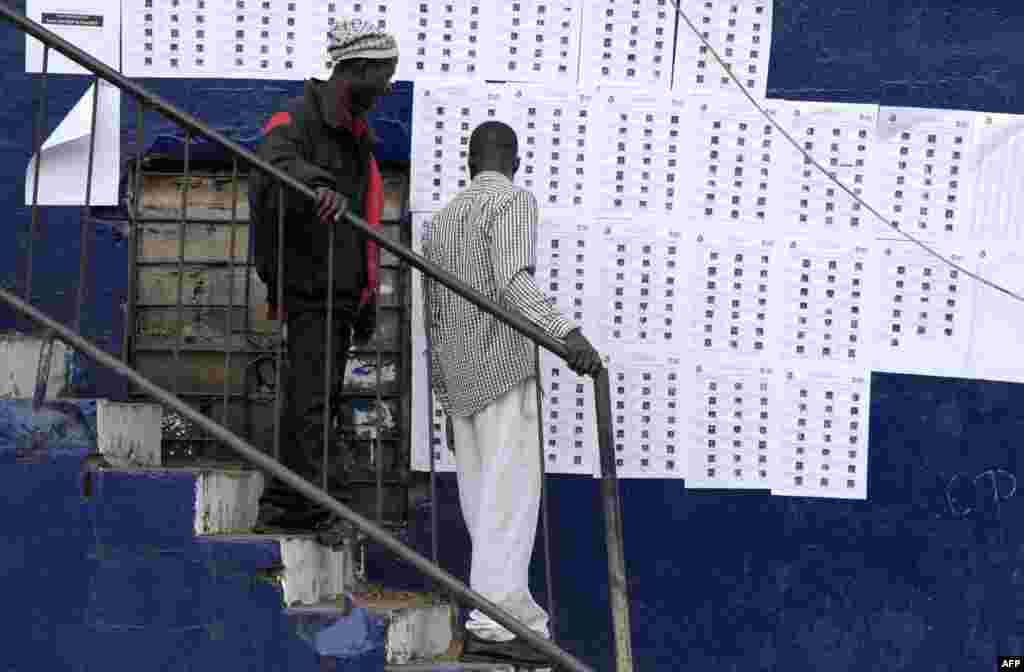 Les électeurs libériens recherchent leurs noms sur des listes postées à l'extérieur d'un bureau de vote à Monrovia, le 26 décembre 2017.
