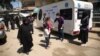 Un membre d'une ONG prend la température d'enfants dans le cadre de la lutte contre le coronavirus à Kafr Takharim, dans la province d'Idleb, en Syrie.
