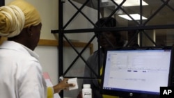 FILE - A woman receives her medication from a pharmacist at the Helen Joseph hospital, in Johannesburg, South Africa, Nov. 15, 2012.