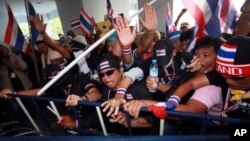 Anti-government protesters try to remove police barricade during a rally in front of the Department of Special Investigation in Bangkok, Thailand, Saturday, Nov. 30, 2013.